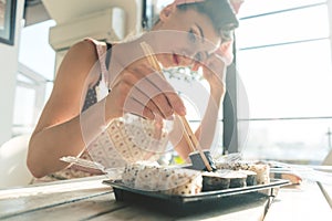 Homemaker woman resting from housework eating some sushi