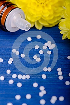 Homeopathic globules on a blue  wooden background