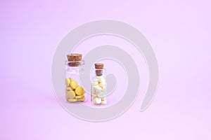 Homeopathic globules and glass bottle on pink background. Alternative Homeopathy