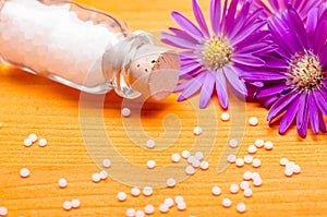 Homeopathic globules on a orange wooden background