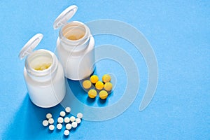 Homeopathic globules and plastic bottle on blue background. Healtcare and pills concept. Vitamins, prebiotics, probiotics. Flat la