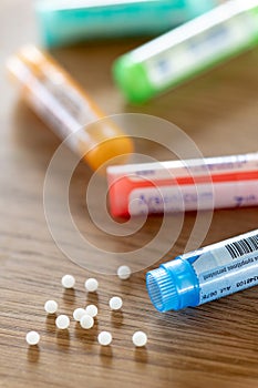 Homeopathic globules scattered around with their colored containers