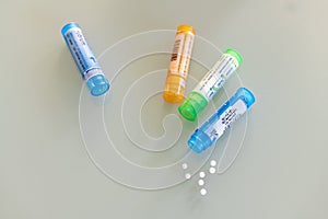 Homeopathic globules scattered around with their colored containers