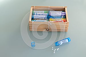 Homeopathic globules scattered around with their colored containers photo