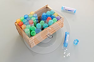 Homeopathic globules scattered around with their colored containers photo