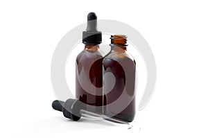 Homeopathic remedy and liquid tincture medicines concept with close up on two brown medicine glass bottles, one open and one