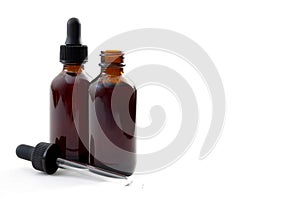 Homeopathic remedy and liquid tincture medicines concept with close up on two brown medicine glass bottles, one open and one