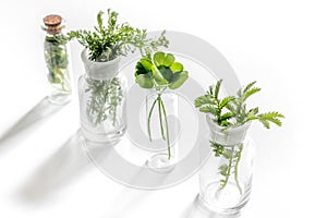 Homeopathy. Medicinal herbs in glass on white background