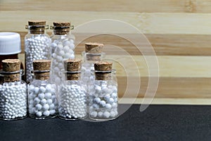 Homeopathy medicine bottles of pills on wooden and dark background. Medicine concept