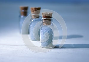Homeopathy pills in vintage bottles on white background.