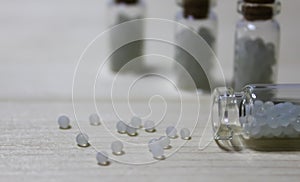 Homeopathy pills in vintage bottles on white background.