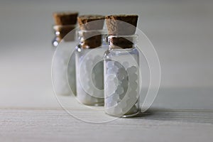 Homeopathy pills in vintage bottles on white background.