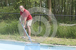 Homeowner cleaning swimming pool