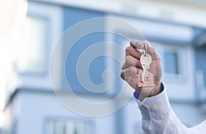 Homeowner holding a new house key from a broker after agreeing to buy a mortgage-home investment. Concept buying a house , a new h