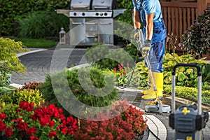 Homeowner Pressure Washing His Bricks Garden Path