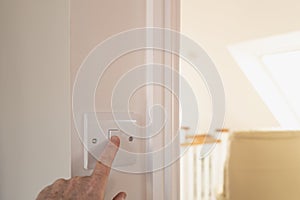 Homeowner seen about to turn off a bedroom light in a bedroom.