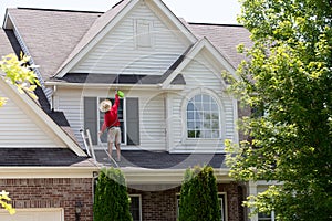 Homeowner washing the exterior of his house
