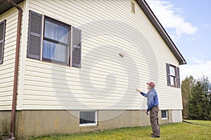 Homeowner washing house vinyl siding