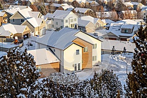 Homes with snowy roofs at a neighborhood in the valley on a sunny winter day