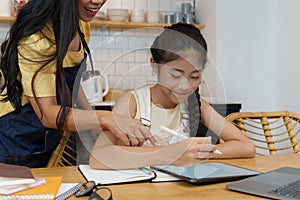 Homeschool Asian mother and little young girl student learning online class. E-learning Online Education concept. photo