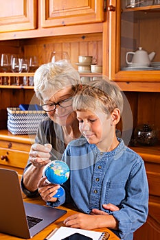 Homeschooling grandmother teaching smart boy, child in geography