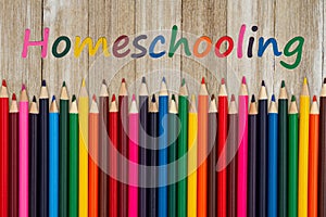 Homeschooling message with pastel color pencils crayons on old wood desk