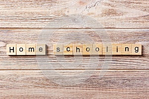 Homeschooling word written on wood block. Home schooling text on table, concept