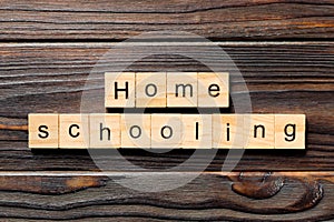 Homeschooling word written on wood block. Home schooling text on table, concept