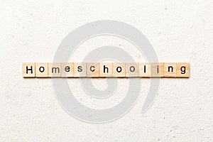 Homeschooling word written on wood block. Homeschooling text on cement table for your desing, Top view concept