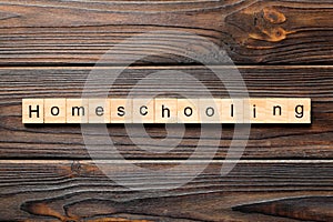 Homeschooling word written on wood block. Homeschooling text on wooden table for your desing, Top view concept