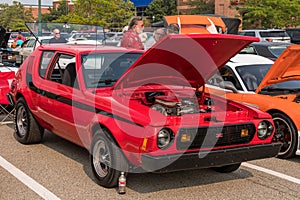 Homestead, Pennsylvania, USA July 21, 2021 A 1977 red with black stripes AMC Gremlin with a modified motor and it`s hood open