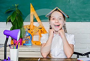 Hometask concept. Girl cute child sit school classroom chalkboard background. Small kid study school. Progress and photo
