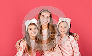 Homewear and pyjamas for tweens. Happy girls smiling in homewear pink background photo