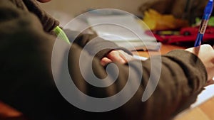 Homework Doer. closeup boy making school homework at home. boy hand with pen, textbook and notebook. boy writes in