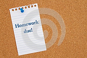 Homework Due message on lined rule paper on corkboard