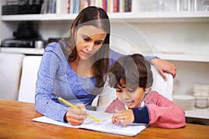 Homework is more fun when Mom helps me do it. a mother helping her son with his homework.
