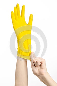 Homework, washing and cleaning of the theme: man's hand holding a yellow and wears rubber gloves for cleaning isolated on white ba