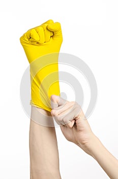 Homework, washing and cleaning of the theme: man's hand holding a yellow and wears rubber gloves for cleaning isolated on white ba