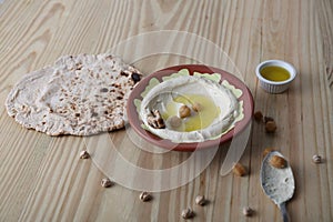 Hommos or hummus with bread, chickpea and sauce served in a dish isolated on table side view of middle east food