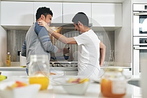 Homosexual Couple Eating Breakfast Cooking In Kitchen