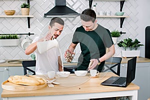 Homosexual couple, gay people, same sex marriage between Caucasian men. Male partners having breakfast and cooking in