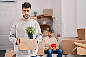 Homosexual couple moving to a new home clueless and confused expression