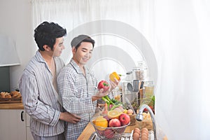Homosexual couple prepairing breakfast in kitchen