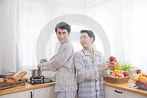 Homosexual couple prepairing breakfast in kitchen