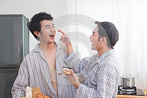 Homosexual couple prepairing breakfast in kitchen together