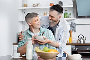 homosexual man holding bowl near husband