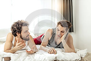 Homosexual married couple talking on bed