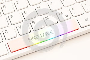 Homosexual online dating concept. White keyboard with rainbow button and an inscription find love