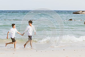 Homosexual portrait young asian couple running with cheerful together on beach in summer