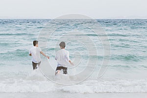 Homosexual portrait young asian couple running with cheerful together on beach in summer